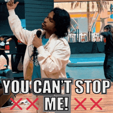 a man singing into a microphone with the words " you can 't stop me "
