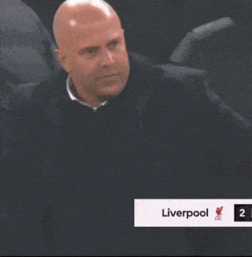 a man is giving a thumbs up in front of a liverpool logo