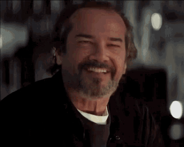 a close up of a man with a beard smiling .
