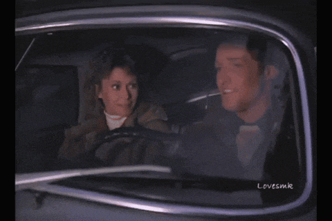 a man and a woman are sitting in a car with lovesmk written on the bottom