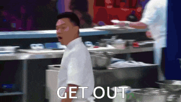 a man in a white shirt is standing in a kitchen with the words get out above him