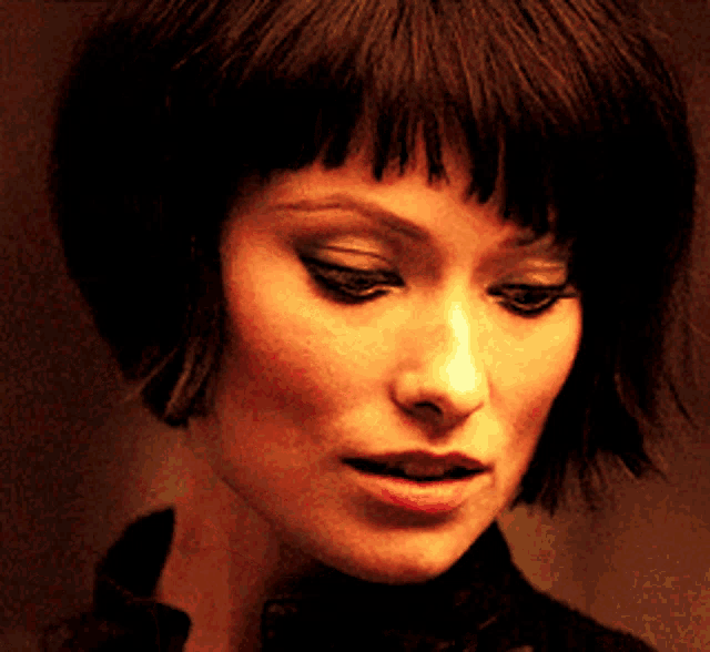 a close up of a woman 's face with a black shirt on