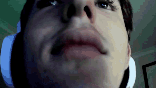 a close up of a man 's face with headphones around his neck