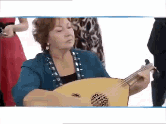 a woman is playing a guitar in front of a microphone .