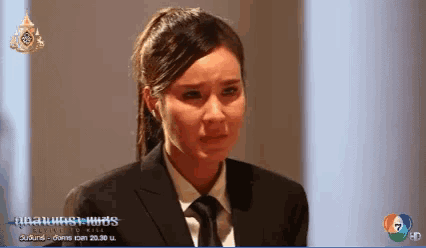 a woman in a suit and tie is crying in front of a screen that says ' evil to kill '