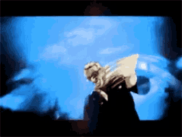 a blurry picture of a person with wings in front of a blue sky