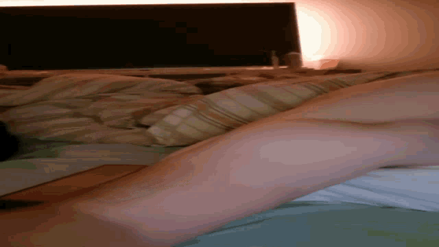 a person laying on a bed with a striped blanket on it
