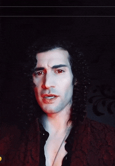 a man with long curly hair and red eyes is wearing a red jacket