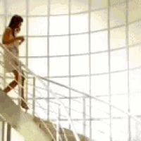 a woman is walking up a set of stairs while talking on a cell phone
