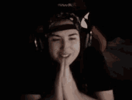 a woman wearing headphones and a hat is sitting in a gaming chair .