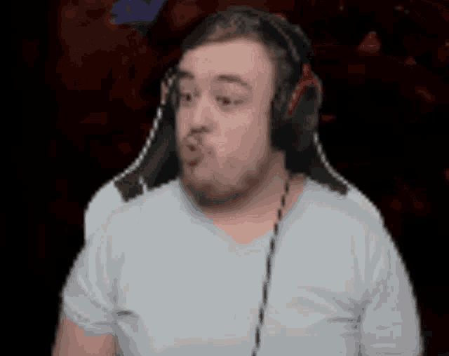 a man wearing headphones and a white shirt is making a funny face