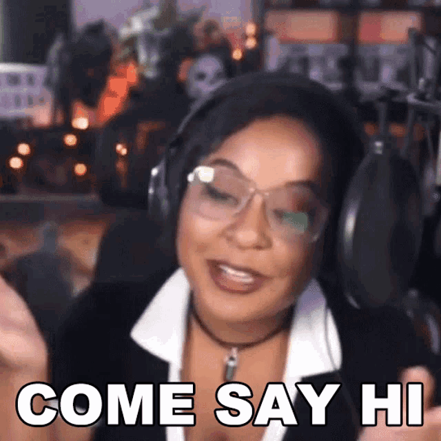 a woman wearing headphones and glasses is saying come say hi