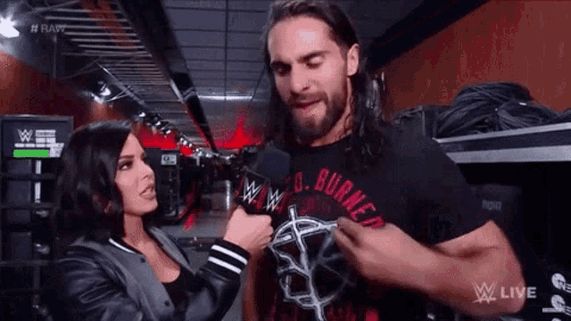 a woman is interviewing a wrestler in a locker room
