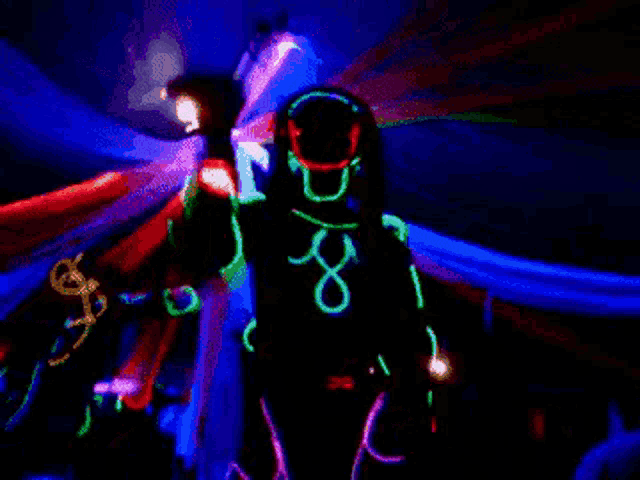 a person wearing glow in the dark clothes is standing in a dark room