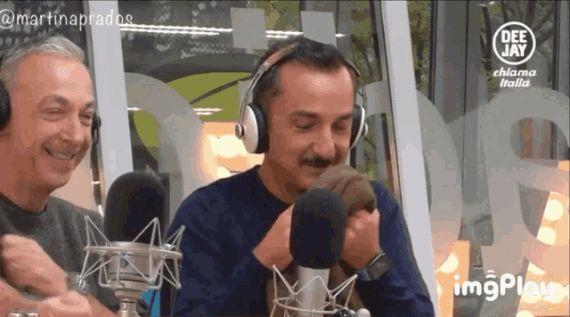 two men wearing headphones are sitting in front of microphones and a sign that says deejay
