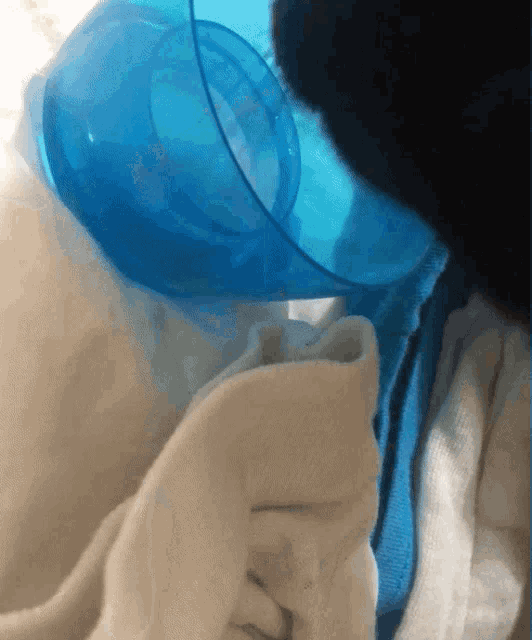 a blue cup is sitting on a white blanket