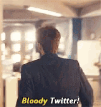 a man in a suit is walking in a hallway and says bloody twitter .