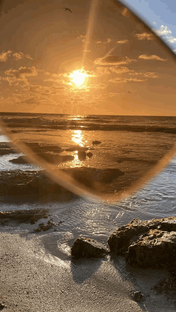 a sunset over the ocean is seen through sunglasses