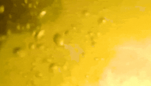 a close up of a yellow background with bubbles coming out of it