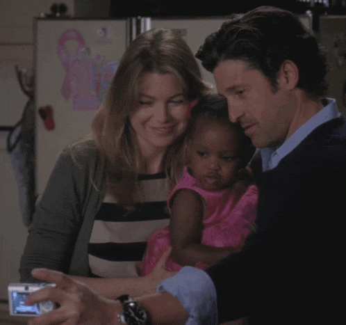 a man is taking a picture of a woman and child with a camera