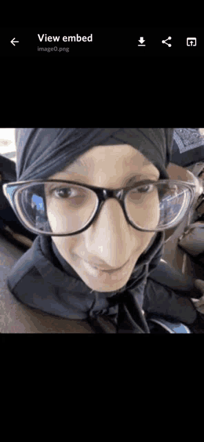 a picture of a woman wearing glasses and a hijab is being viewed