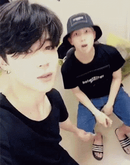 a man wearing a hat is sitting next to another man wearing a black shirt .