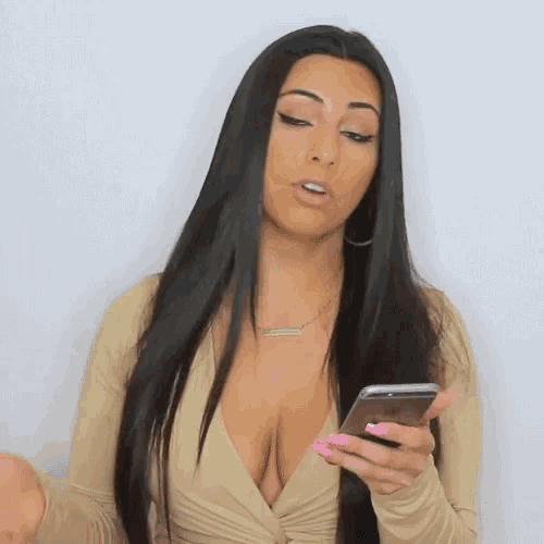 a woman with long black hair is holding a cell phone in her hand