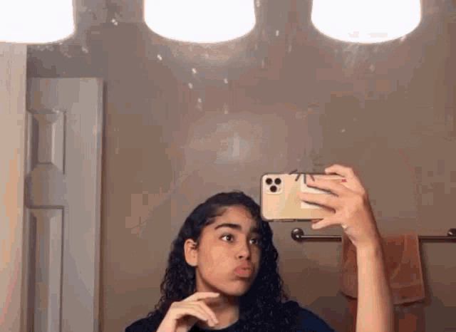 a girl is taking a selfie in front of a mirror