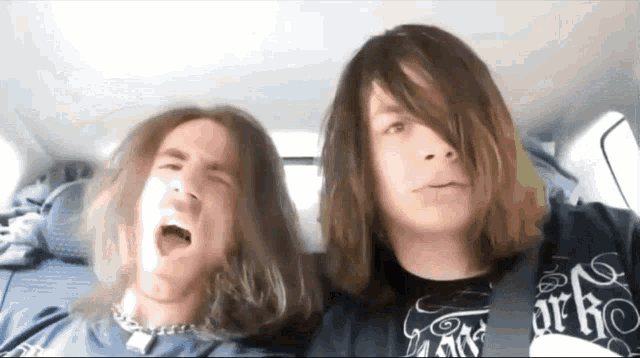 a man with long hair is wearing a shirt that says ' earth ' on it