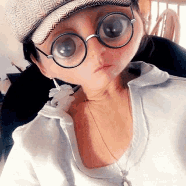 a woman wearing a hat and glasses looks like a baby