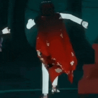 a woman in a red dress is dancing in the dark