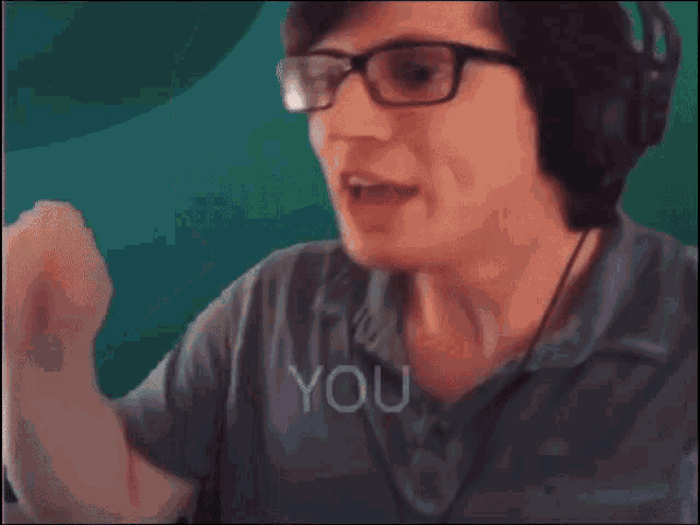 a man wearing glasses and headphones says cannot in front of a green background