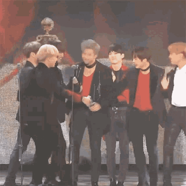a group of people hugging each other on a stage