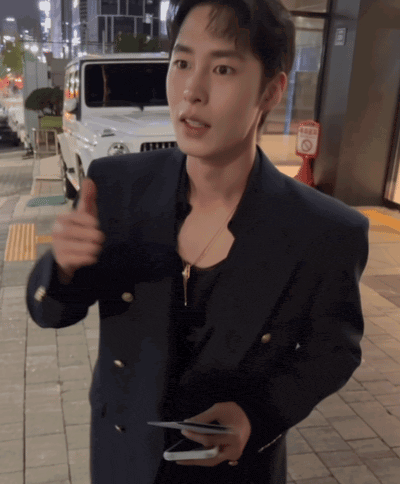 a man in a suit holds a cell phone in his hand
