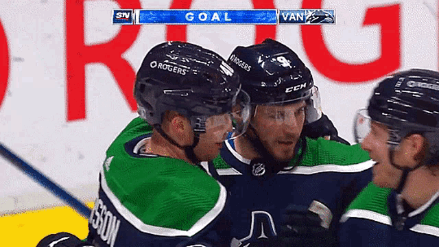 a hockey team celebrates a goal against the vancouver bruins