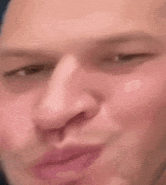 a close up of a man 's face making a funny face with his eyes closed .