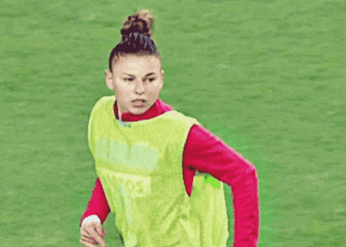 a woman wearing a yellow vest that says lotos