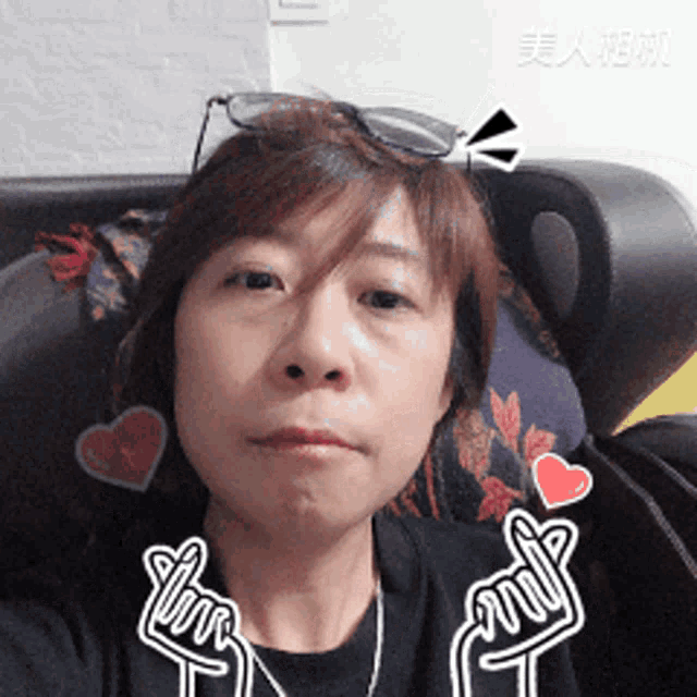 a woman wearing glasses and a black shirt has a sticker on her neck that says " love "