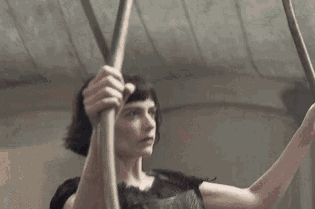 a woman is hanging from a rope in a room .