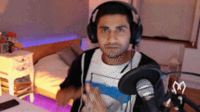 a man wearing headphones stands in front of a microphone in a room