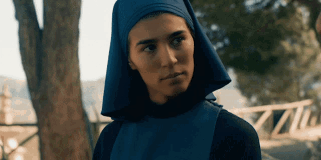 a woman wearing a blue head scarf and a black top