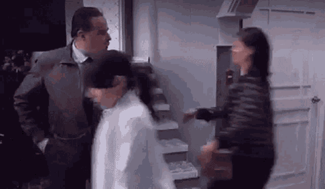 a man and a woman are standing next to each other in a kitchen .