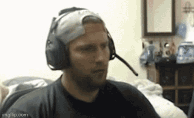 a man wearing headphones and a hat has a sticker on his head that says ' imgflip.com ' .