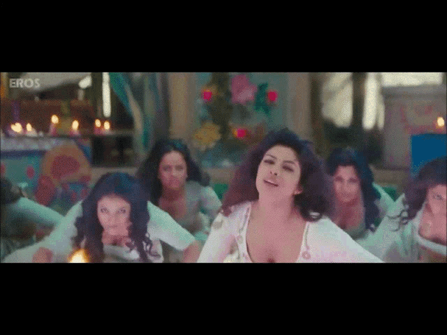 a group of women are dancing in a room with the word eros on the bottom