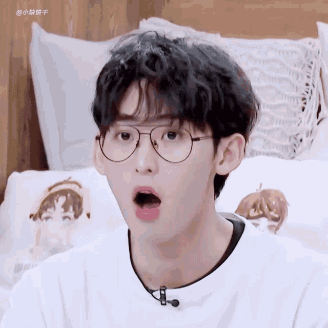a close up of a person wearing glasses with a surprised look on his face