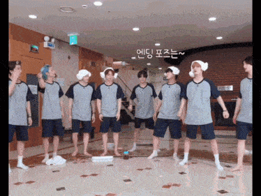 a group of young men standing in a room with korean writing on the wall