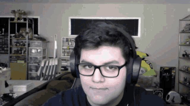 a man wearing headphones and glasses is looking at the camera