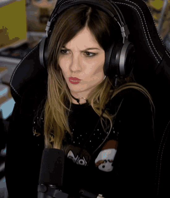 a woman wearing headphones and a choker is sitting in a chair