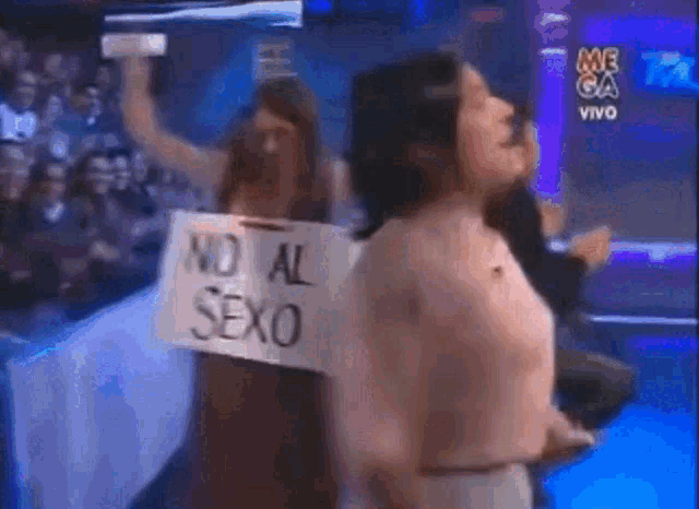 a woman holding a sign that says no al sexo on it
