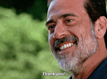 a man with a beard and mustache is smiling and says thank you